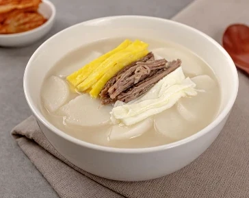 一碗配有牛肉和蛋丝的年糕汤。
